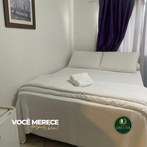 a bed in a room next to a window at Hotel Gaucha in Guaíra