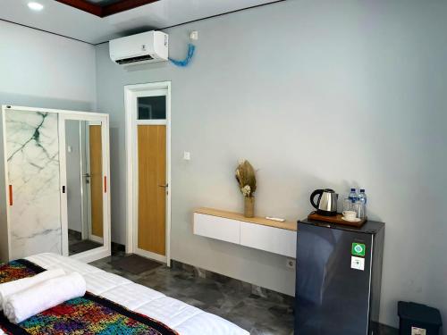 a room with a bed and a sink and a mirror at suka homestay in Sanur