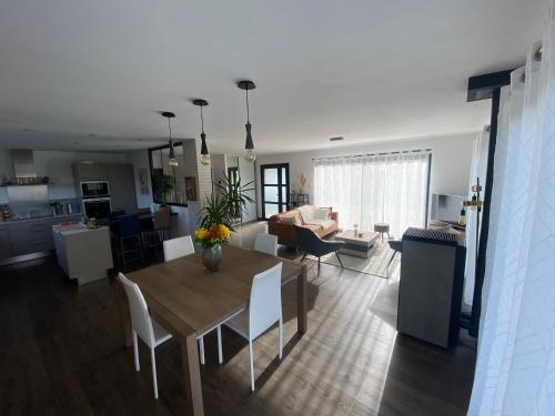 un salon et une salle à manger avec une table et des chaises dans l'établissement Maison proche des plages du D-Day, à Thaon