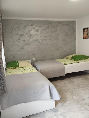 a bedroom with two beds and a wall at Pokój dwuosobowy Sosnowa in Krasnobród
