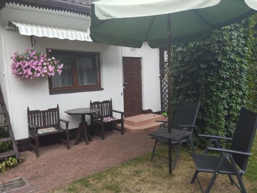 a patio with tables and chairs and an umbrella at Pokój dwuosobowy Sosnowa in Krasnobród