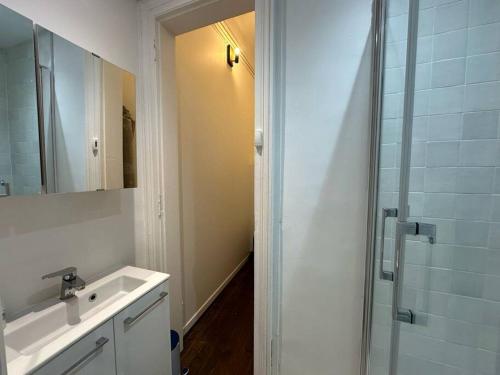 une salle de bain avec une douche, un lavabo et un miroir dans l'établissement Historique - Studio proche Cathédrale, à Reims