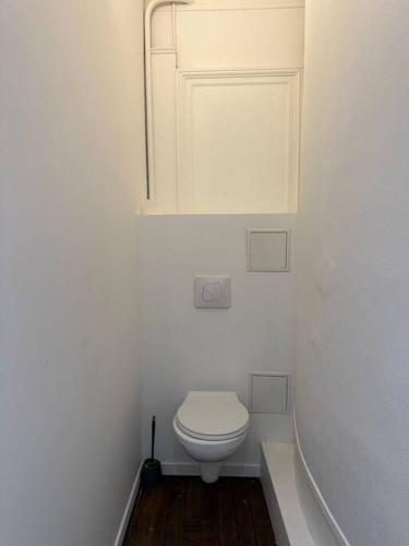 La salle de bains blanche est pourvue de toilettes et d'une armoire. dans l'établissement Historique - Studio proche Cathédrale, à Reims