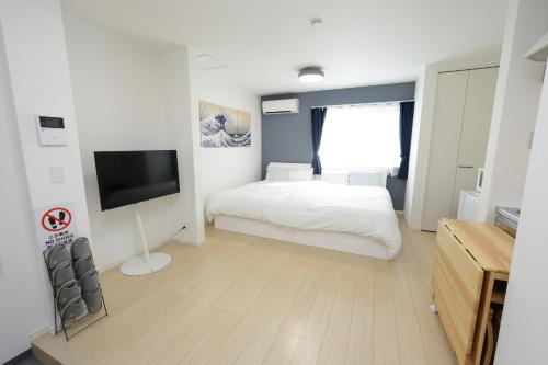 a bedroom with a bed and a flat screen tv at Rana片瀬江ノ島 in Fujisawa