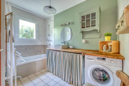 La salle de bains est pourvue d'un lave-linge et d'une baignoire. dans l'établissement Maison calme et vue foret, à Andernos-les-Bains