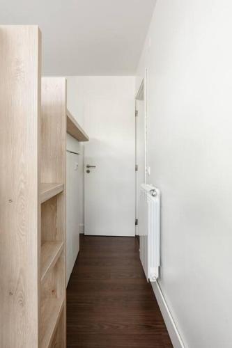 a hallway with wooden floors and a white wall at Casa do Pai Beach House in Aldeia do Meco