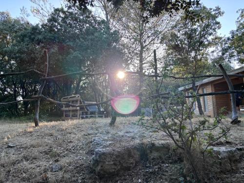 a playground in a yard with the sun shining at Éco Lodge - Nature et Spa in Aurons