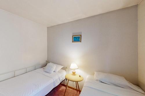 two beds in a room with a table and a lamp at Chestnut Hill Hideaway in Lake Ariel