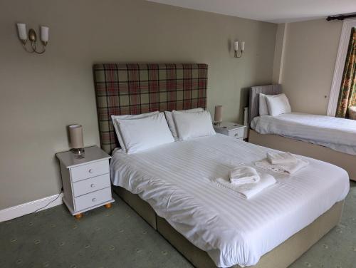 a bedroom with two beds with white sheets and a night stand at The Buck in Richmond