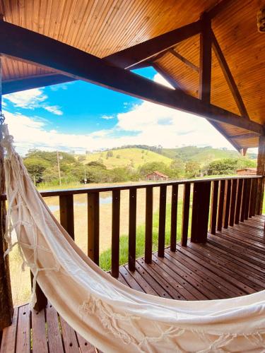 a hammock on a deck with a view of the mountains at Chale com hidro na Serra da Mantiqueira in Sapucaí-Mirim