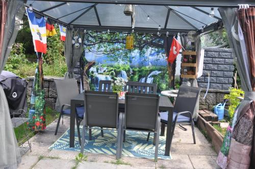 una mesa y sillas en un cenador en Ferienwohnungen Alter Raaben, en Rüti