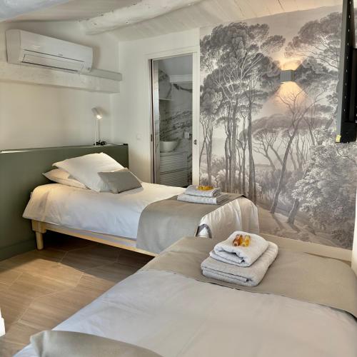 - une chambre avec 2 lits et une fresque murale dans l'établissement Centre Historique Appartement Climatisé avec terrasse, à Aix-en-Provence
