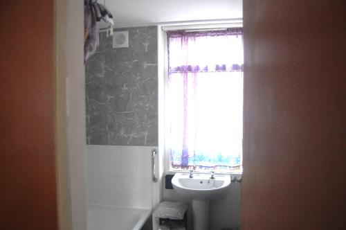 Un baño con lavabo y ventana. en Dawlish Warren Welcome family holiday park Fern villa Welcome2Warren South Devon, en Dawlish Warren