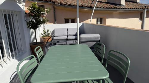 d'une table et de chaises vertes sur un balcon dans l'établissement Centre Historique Appartement Climatisé avec terrasse, à Aix-en-Provence