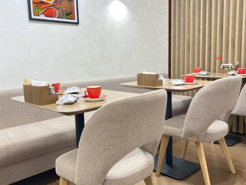a restaurant with two tables and chairs with cups on them at Grand Christer Hotel in Kyiv