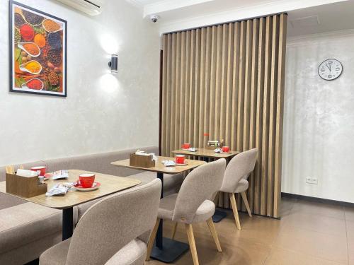 a restaurant with two tables and chairs and a clock at Grand Christer Hotel in Kyiv