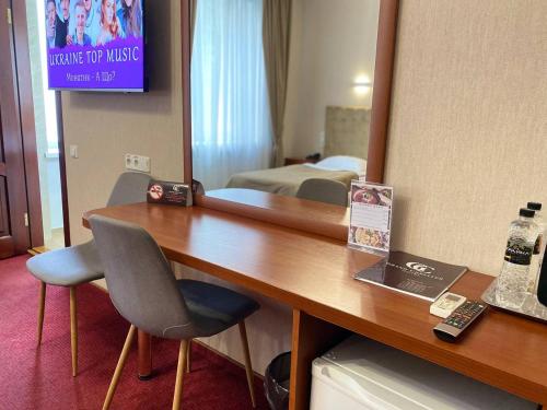 a hotel room with a desk and a television at Grand Christer Hotel in Kyiv