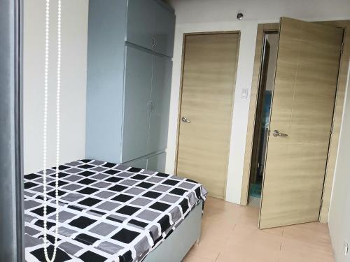 a bedroom with a black and white checkered bed at Centro Tower - 2 Bedroom Fully Furnished in Manila