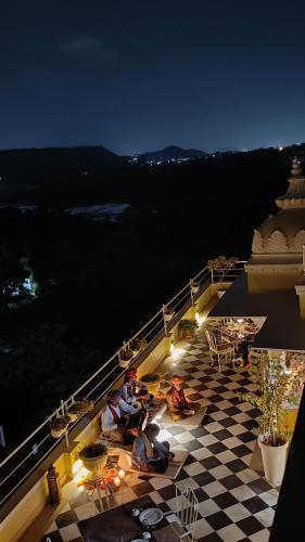 two people sitting on the deck of a cruise ship at night at Burj Baneria - A Boutique Homestay in Udaipur