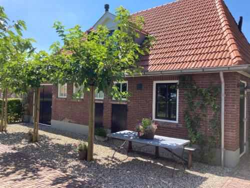 a small brick house with a picnic table in front of it at House of Flowers, Gendringen, Achterhoek, Gelderland in Gendringen