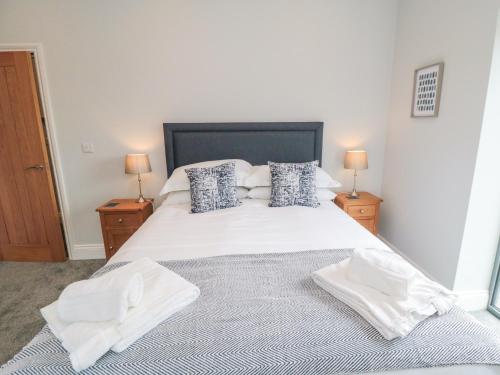 a bedroom with a large white bed with two lamps at The Stables in Thirsk