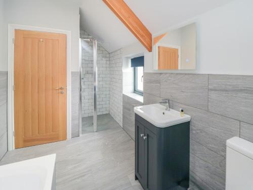 a bathroom with a sink and a toilet and a door at The Stables in Thirsk