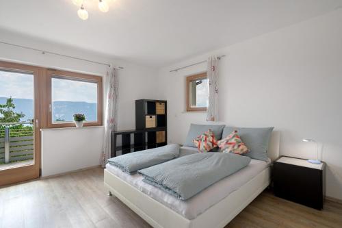 a white living room with a couch and a window at Villa Reny in Meltina