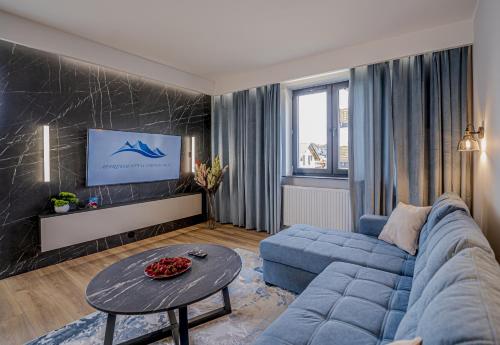a living room with a blue couch and a table at Apartament w Cieplicach Prime in Jelenia Góra