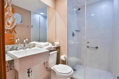 a bathroom with a toilet and a sink and a shower at eSuites Belo Horizonte Minascasa in Belo Horizonte
