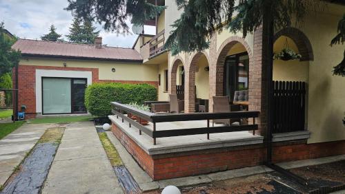 a house with a bench on the side of it at WILLA BAJLAND in Warsaw