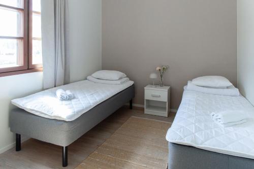 two twin beds in a room with a window at Visulahti Cottages in Mikkeli