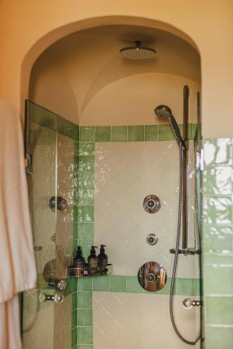 a shower in a bathroom with green tile at Aethos Hotel Sardinia in Cannigione