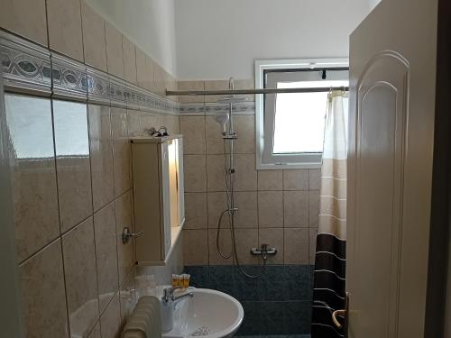 a bathroom with a sink and a shower at White Villa in Xylokastro