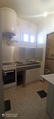 une cuisine avec un évier et une cuisinière four supérieur dans l'établissement petite maison plain pied, à Cuxac-dʼAude