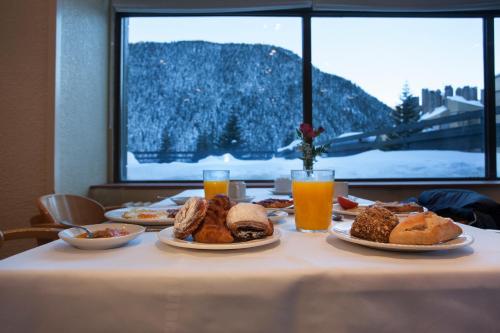 a table with plates of food and glasses of orange juice at Tuc Blanc in Baqueira-Beret