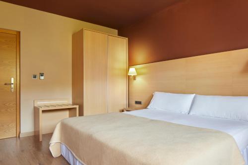 a bedroom with a large white bed in a room at Iraipe Santuario de Arantzazu Hotel in Oñate