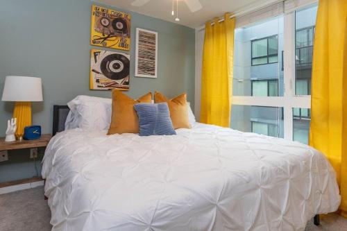 a large white bed in a room with a window at Self Check-in-washer-dryer-4ksmart Tv-king Bed-gym in Tacoma