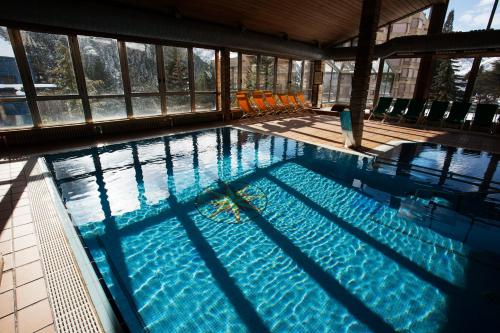 a large swimming pool with chairs in a building at Tuc Blanc in Baqueira-Beret