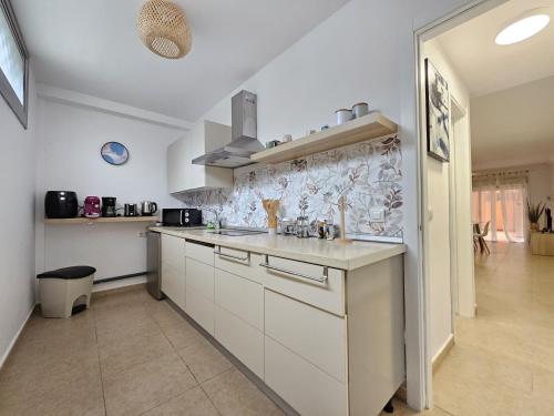 a kitchen with white cabinets and a counter top at Appartamento Oceano - Playa San Juan in Playa de San Juan