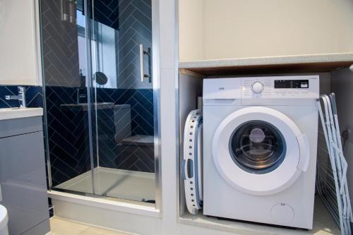 a washing machine in a bathroom next to a shower at Stunning House - Sleeps 7 - 5 Mins walk to Lincoln High Street - Parking - Wifi in Lincolnshire