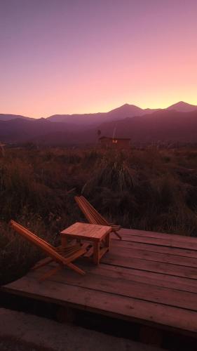 a picnic table and a chair sitting on a wooden deck at Las Ranas in Tilcara