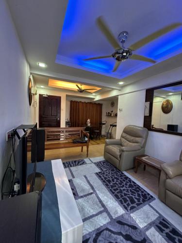 sala de estar con ventilador de techo y sofá en Teluk Air Tawar Home, en Butterworth