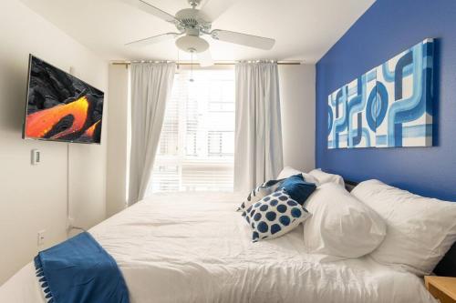 Un dormitorio con una cama blanca con una pared azul. en Paid Garage Parking- King Bed-balcony Wd 55" Tv, en Tacoma