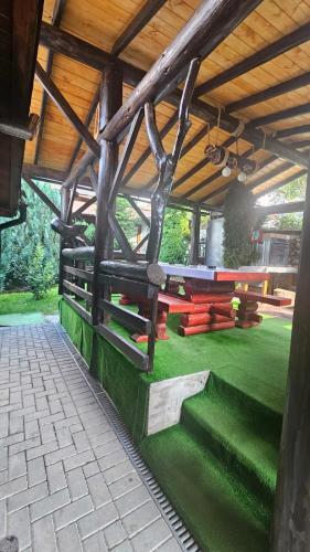 a pavilion with green grass and a wooden roof at Pensiunea Mia in Statiunea Borsa