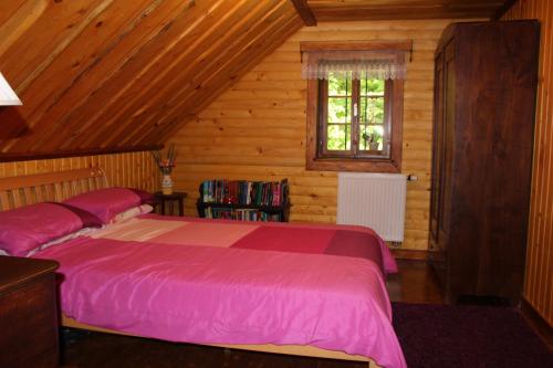 a bedroom with two beds in a wooden cabin at Na Gmajni pr' Angležu in Gabrovka
