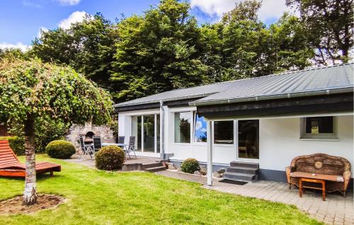 a white house with a patio and a garden at Holiday Home Gunderath With Fireplace I in Gunderath