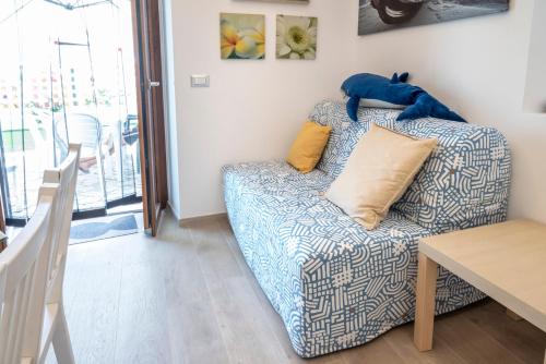 un salon avec un canapé bleu et blanc dans l'établissement M407 - Marcelli, trilocale direttamente sul mare, à Marcelli