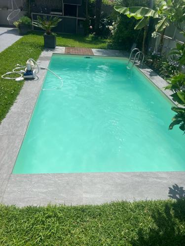 une grande piscine bleue dans une cour dans l'établissement Maison avec piscine, à Tarnos