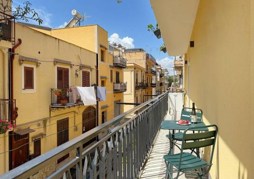 Un balcón con una mesa y sillas en un balcón. en Solemar Sicilia - Casa Minerva, en Santa Flavia
