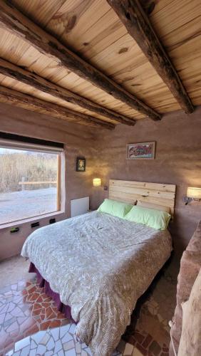 a bedroom with a large bed with a window at Las Ranas in Tilcara